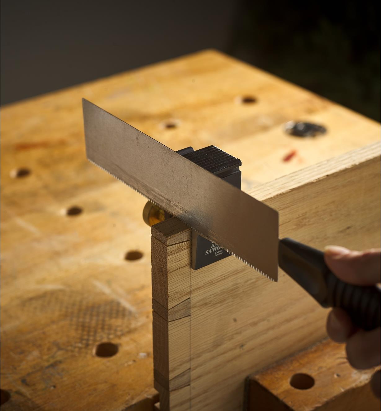 A saw flush against a Veritas Dovetail Guide that is clamped to a workpiece