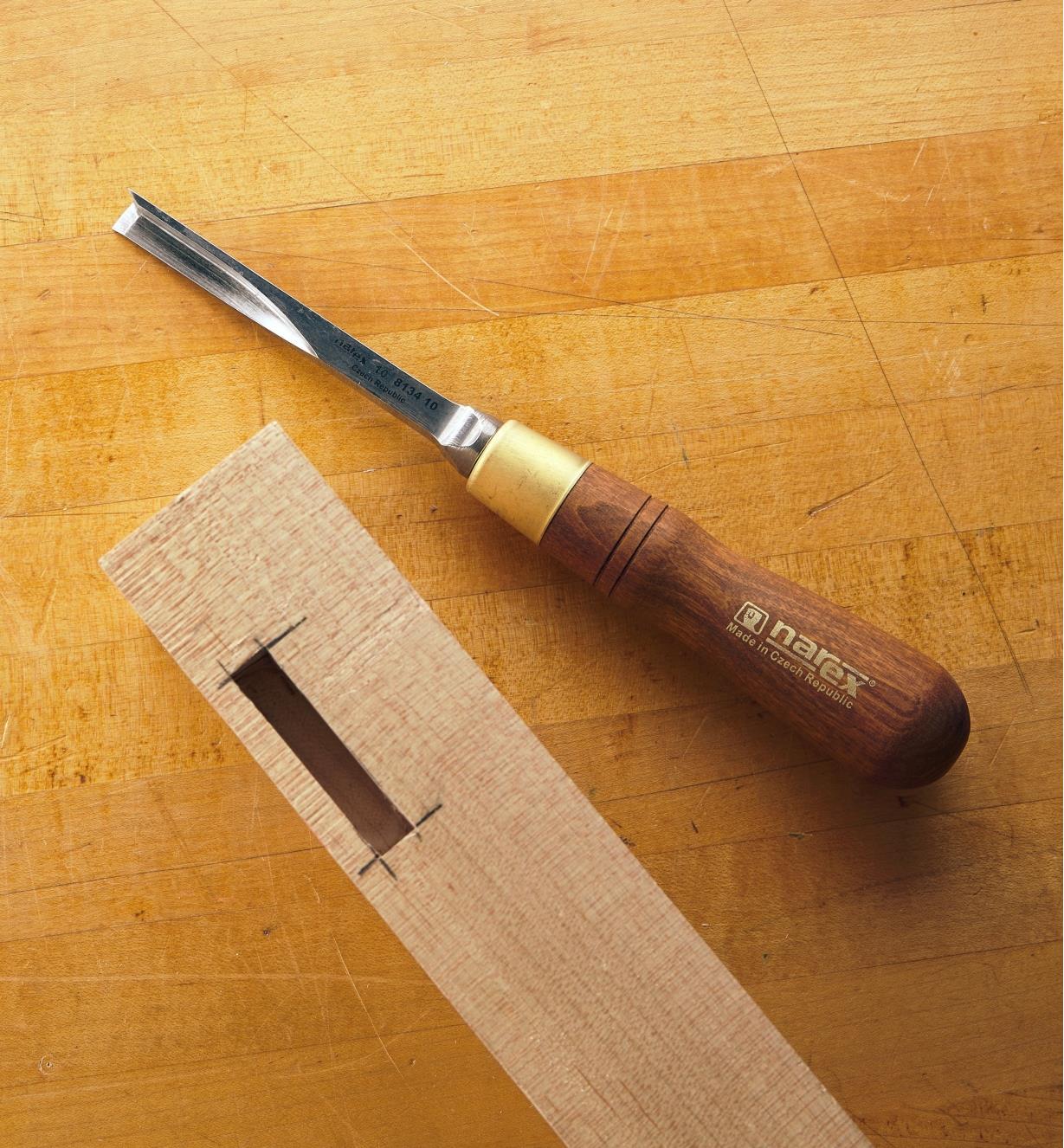 Wood with a mortise next to a corner chisel