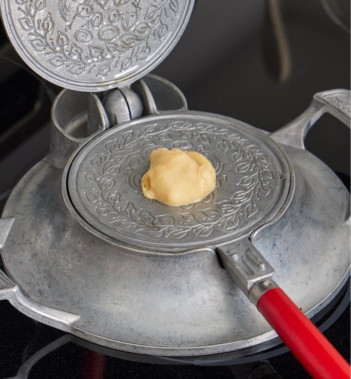 A small amount of batter placed in the center of the griddle plate of the krumkake and pizzelle iron