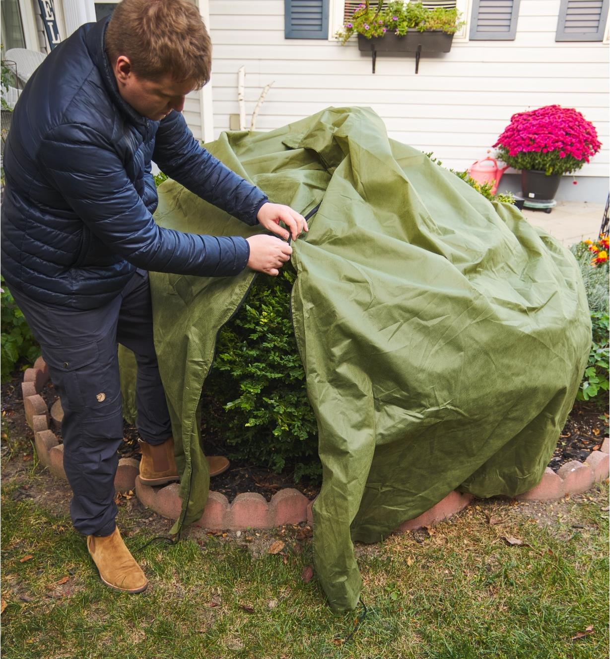 The Shrub & Potted Plant Protector being zipped over a shrub in a garden