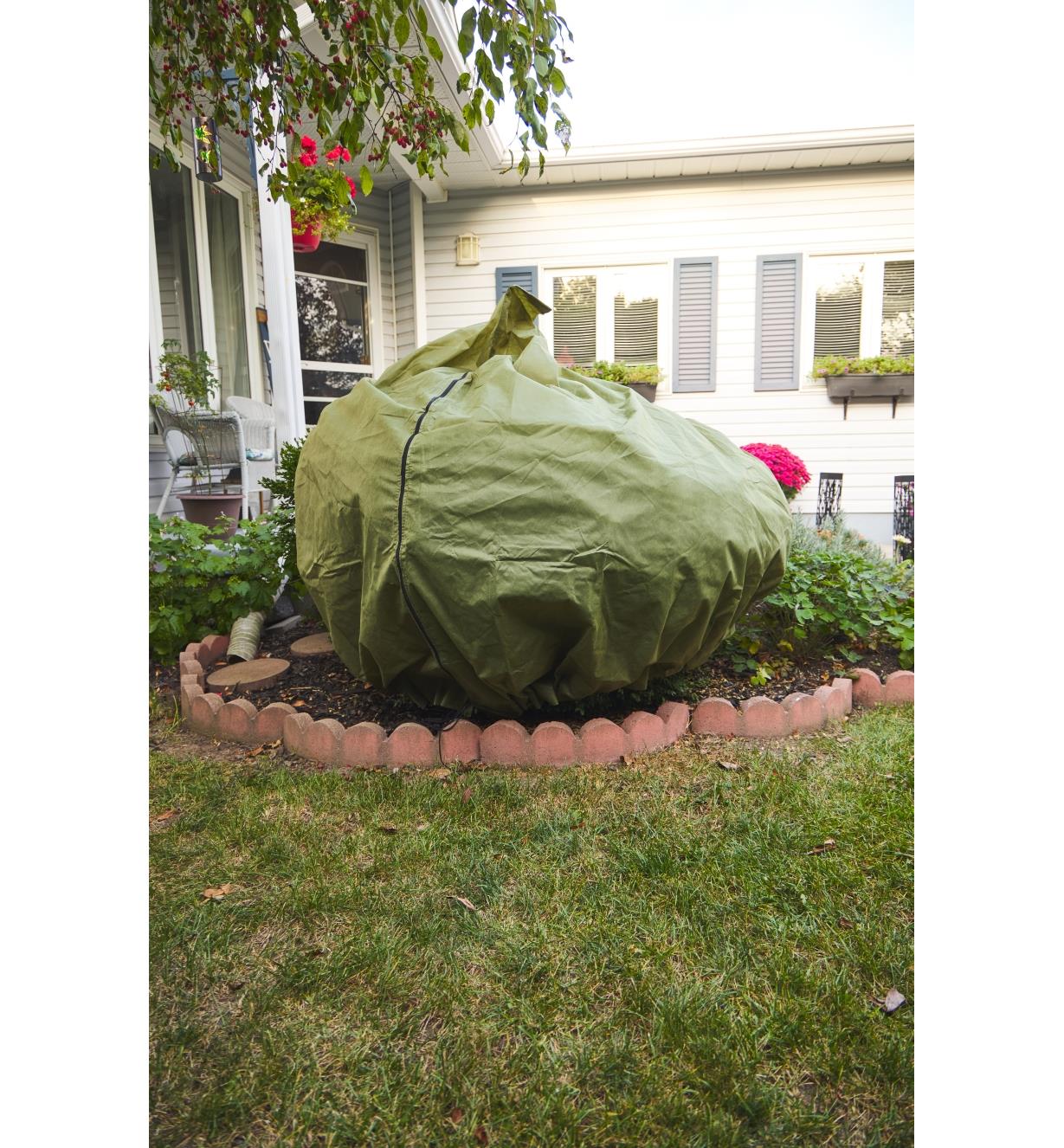 The Shrub & Potted Plant Protector zipped over a shrub in a garden