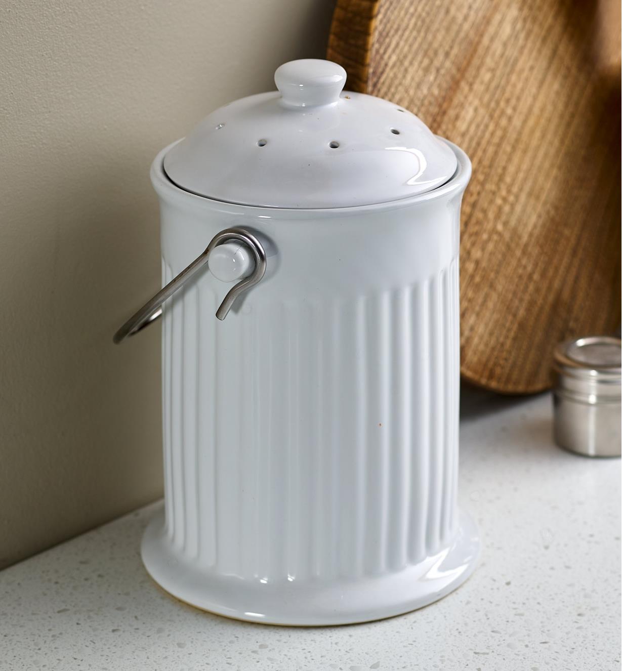 A porcelain compost pail on a kitchen countertop