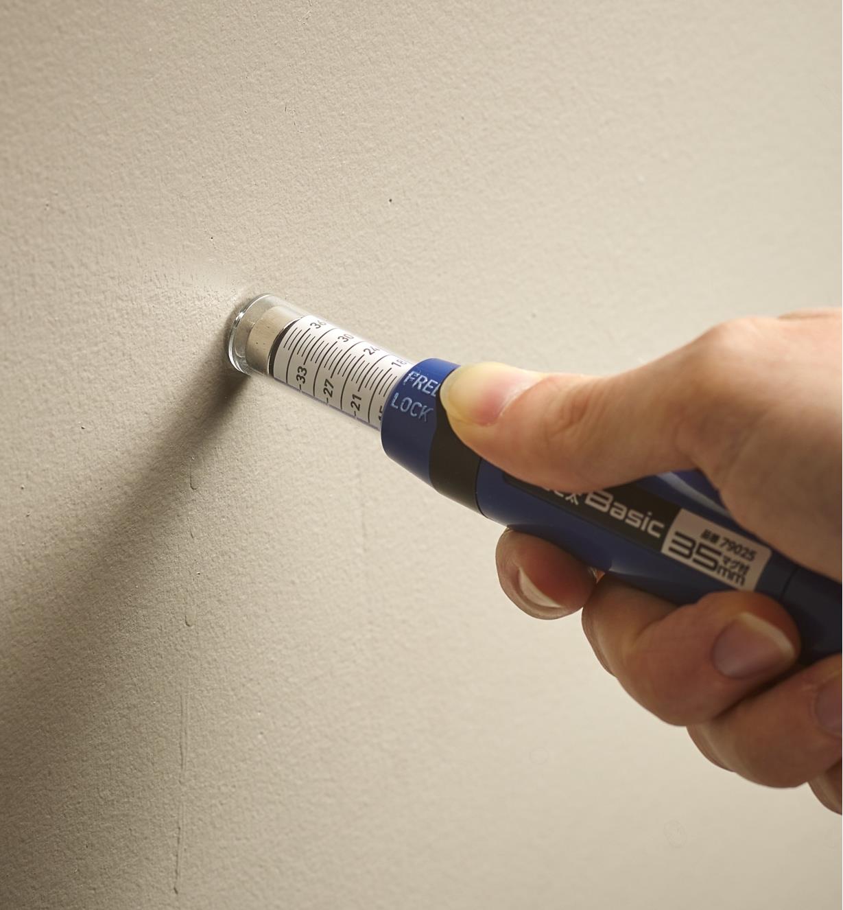 A stud finder pressed against a wall