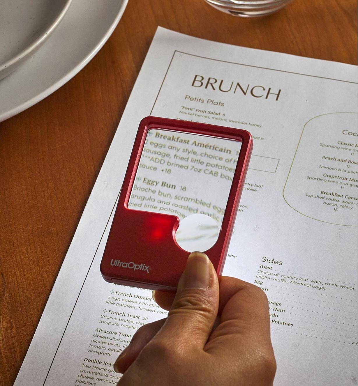 Using an LED pocket magnifier to read a menu in a dimly lit restaurant