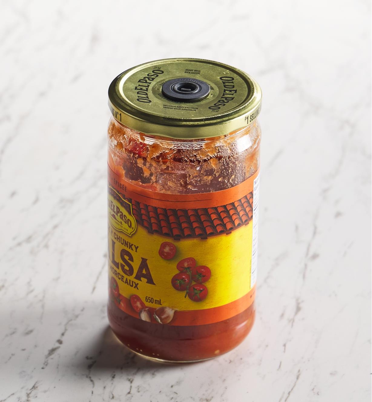 A jar of salsa with an Airtender stopper valve set in the lid