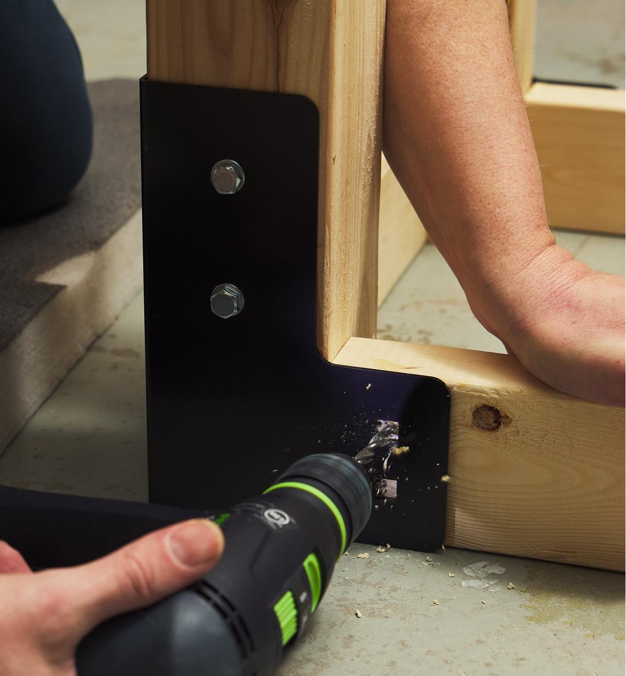 Drilling a pilot hole into one of the 2x4 runners in a table made with a utility table hardware kit