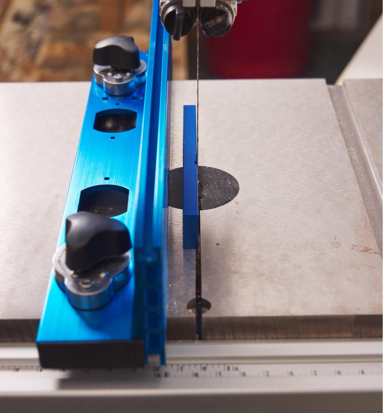 A F.A.S.T. fence magnetic block attached to a bandsaw blade, with a magnetic fence to the left of it, ready for alignment