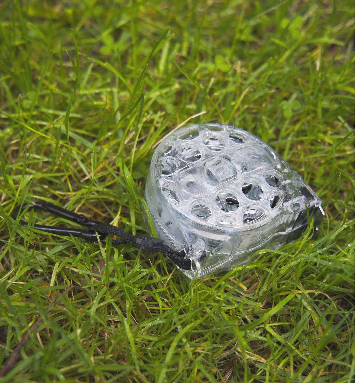 A washable tape measure lying in wet grass
