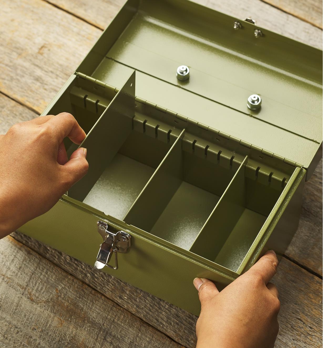 A person arranges the repositionable dividers inside a seed keeper box