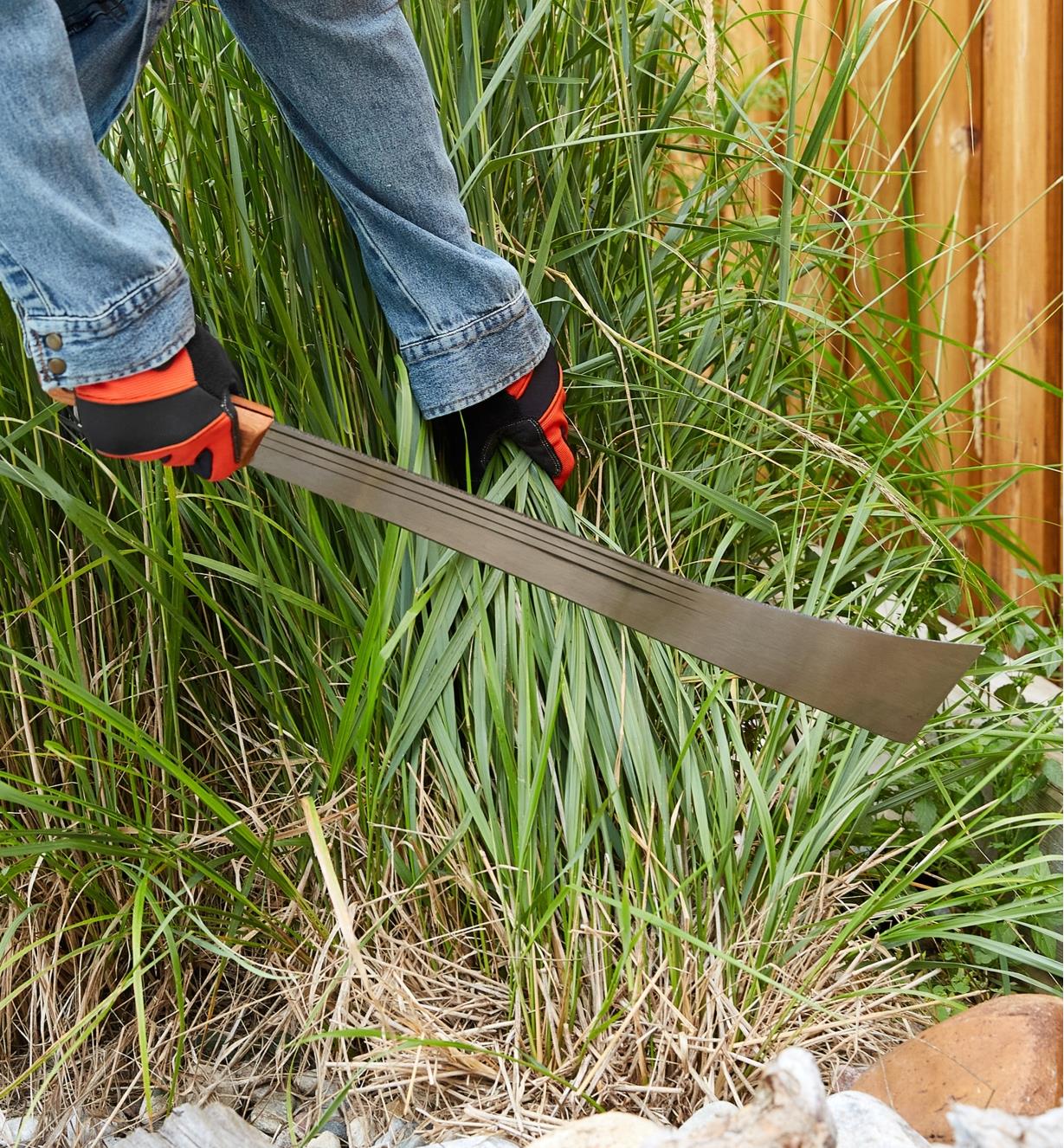 Cutting tall grass with a machete