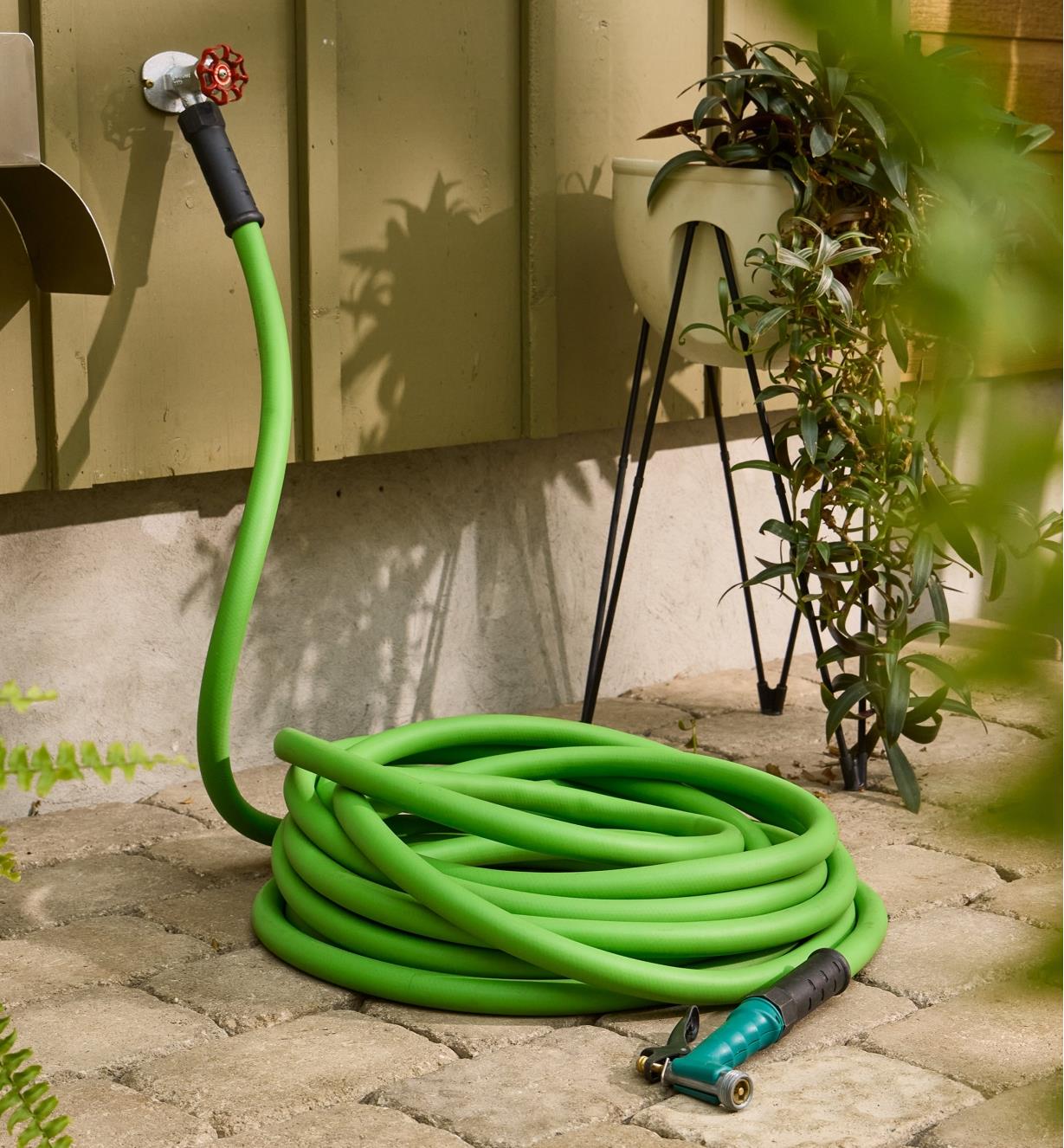 3/4" garden hose lies on the ground while connected to an outdoor tap