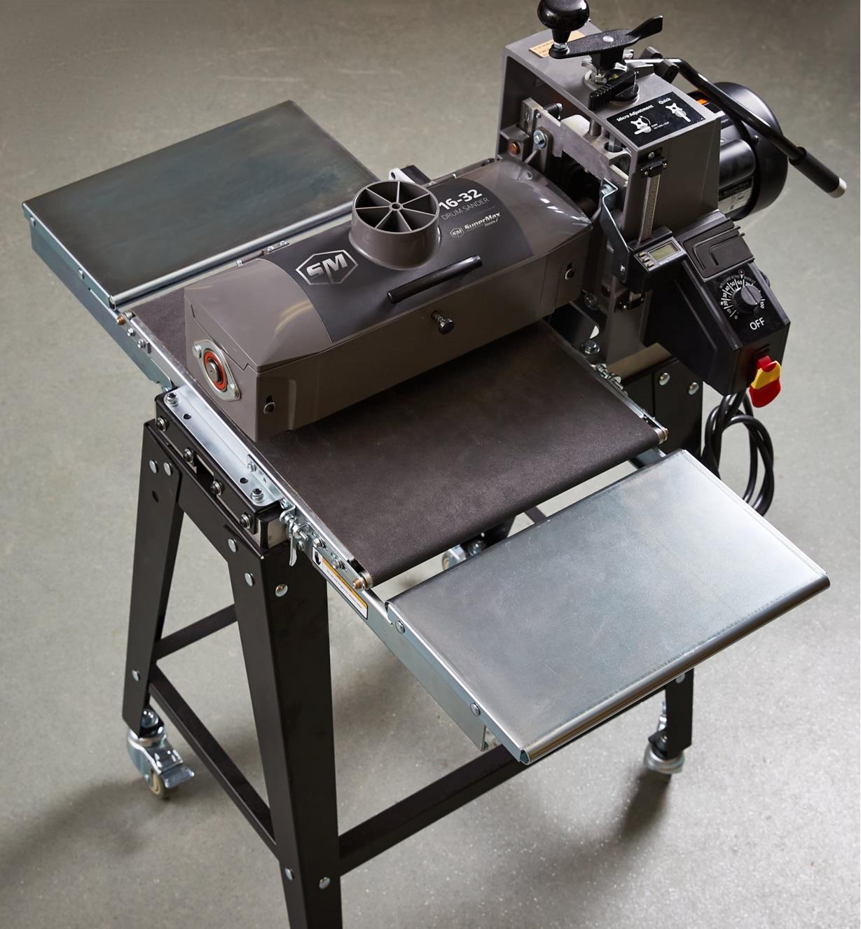 Infeed/outfeed tables attached to either side of a drum sander with a stand