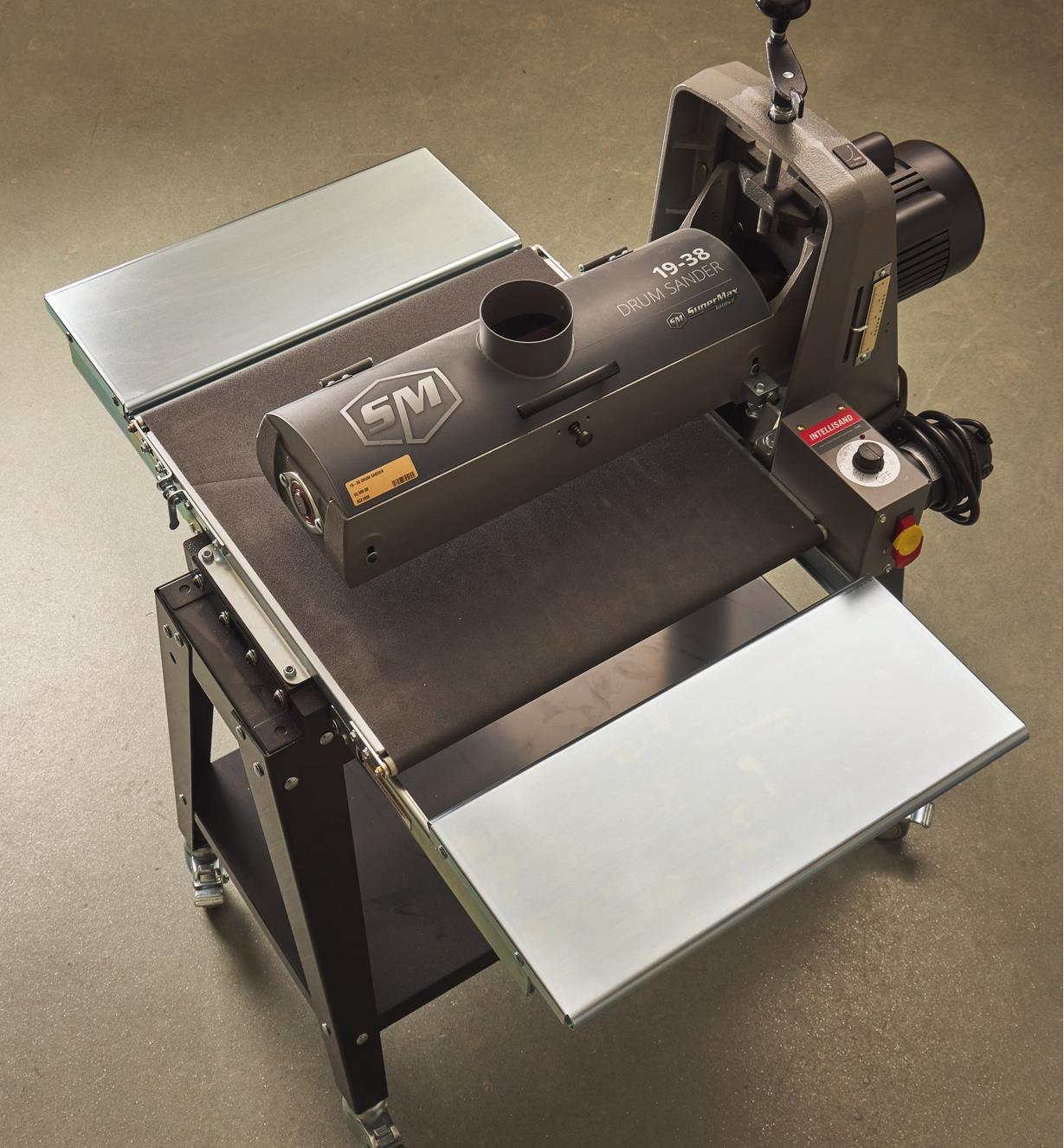 A drum sander with raised infeed/outfeed tables