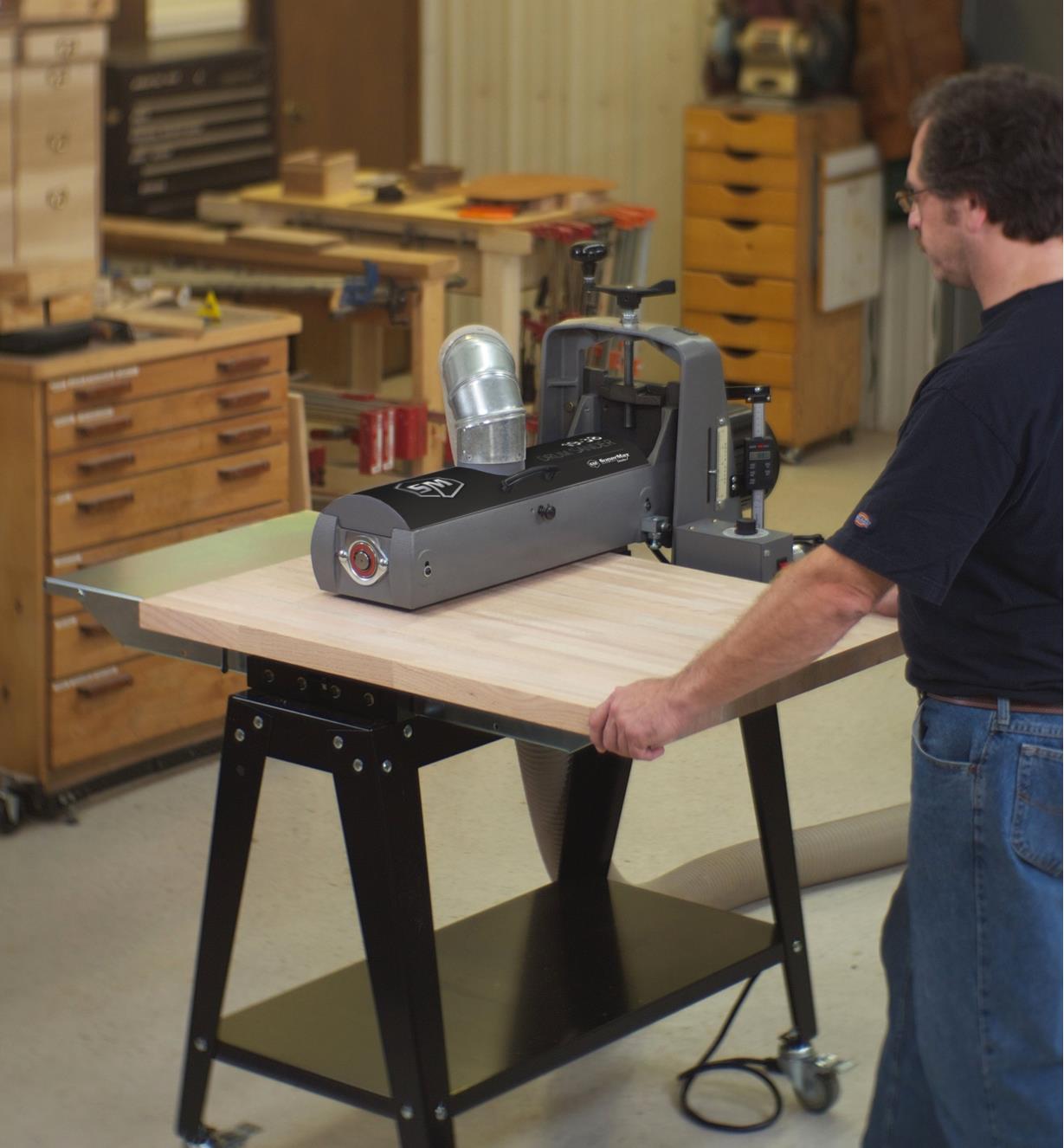 A wide board being fed through the 19-38 drum sander
