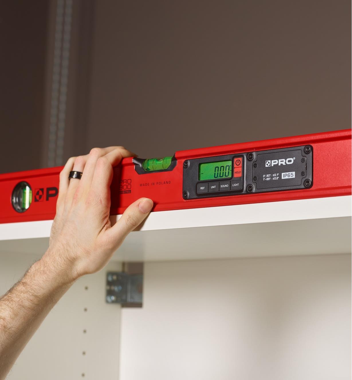 Using a digital level's audio signal to check a high shelf where the LCD would be hard to read