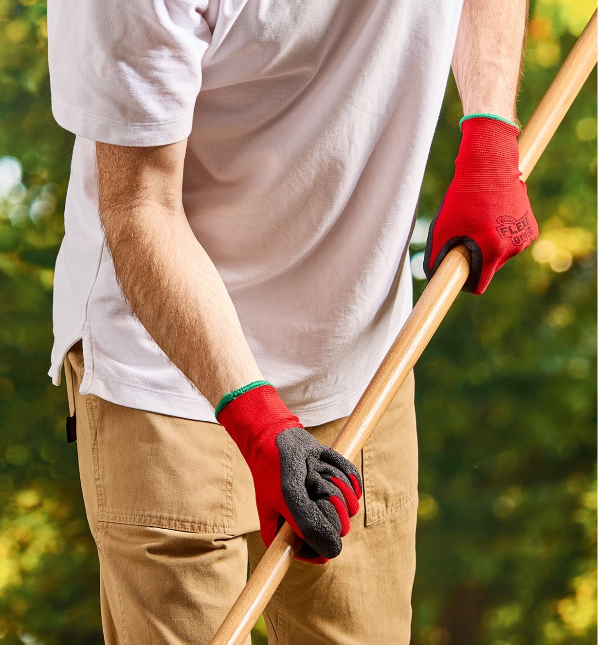A man wears Flex Grip gloves while raking