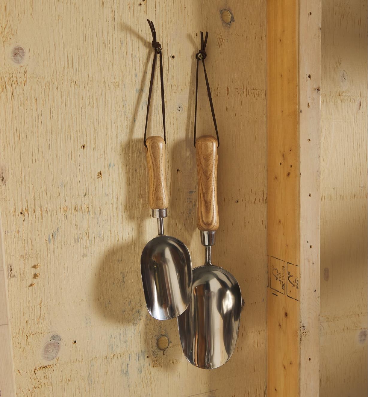 1/2 cup and 1 cup stainless-steel scoops hang on a wall