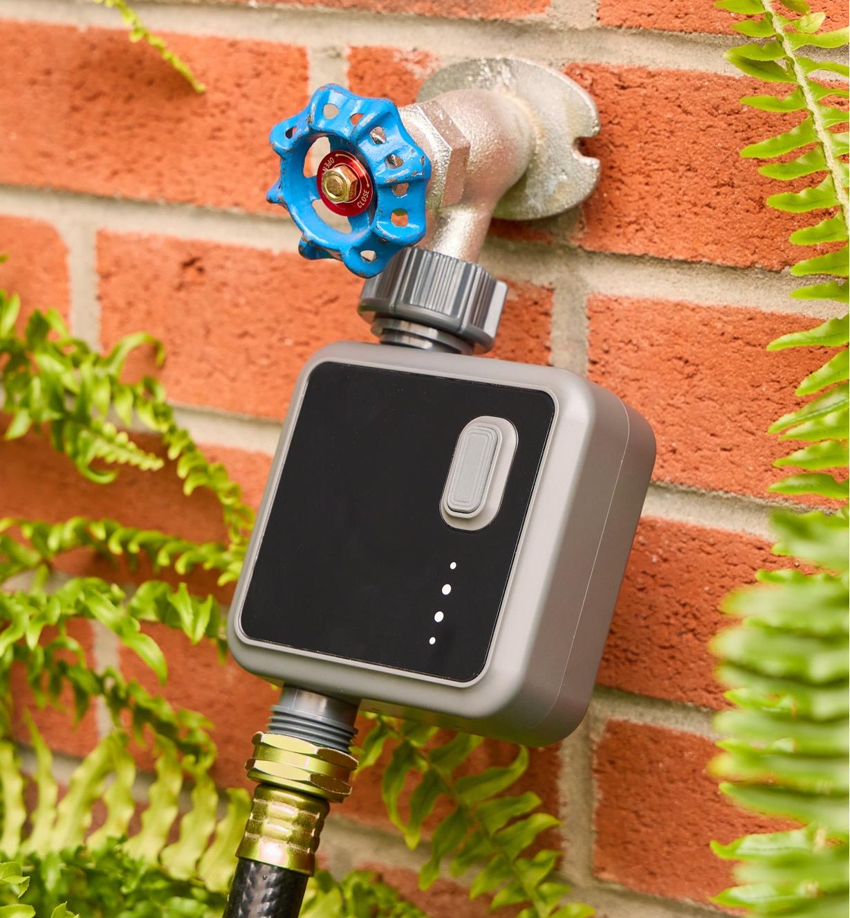 The Wi-Fi one zone water timer connected to an outdoor tap with a hose attached to the bottom