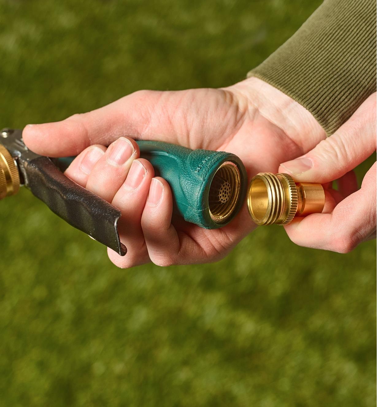 A gardener connects the brass male tool adapter to a hose nozzle