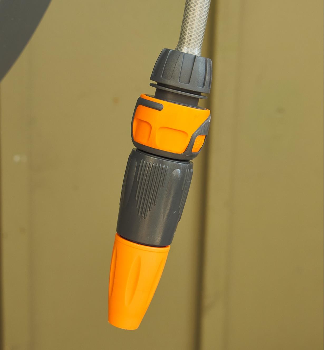 A spray gun connected to a hose hangs from the hose reel