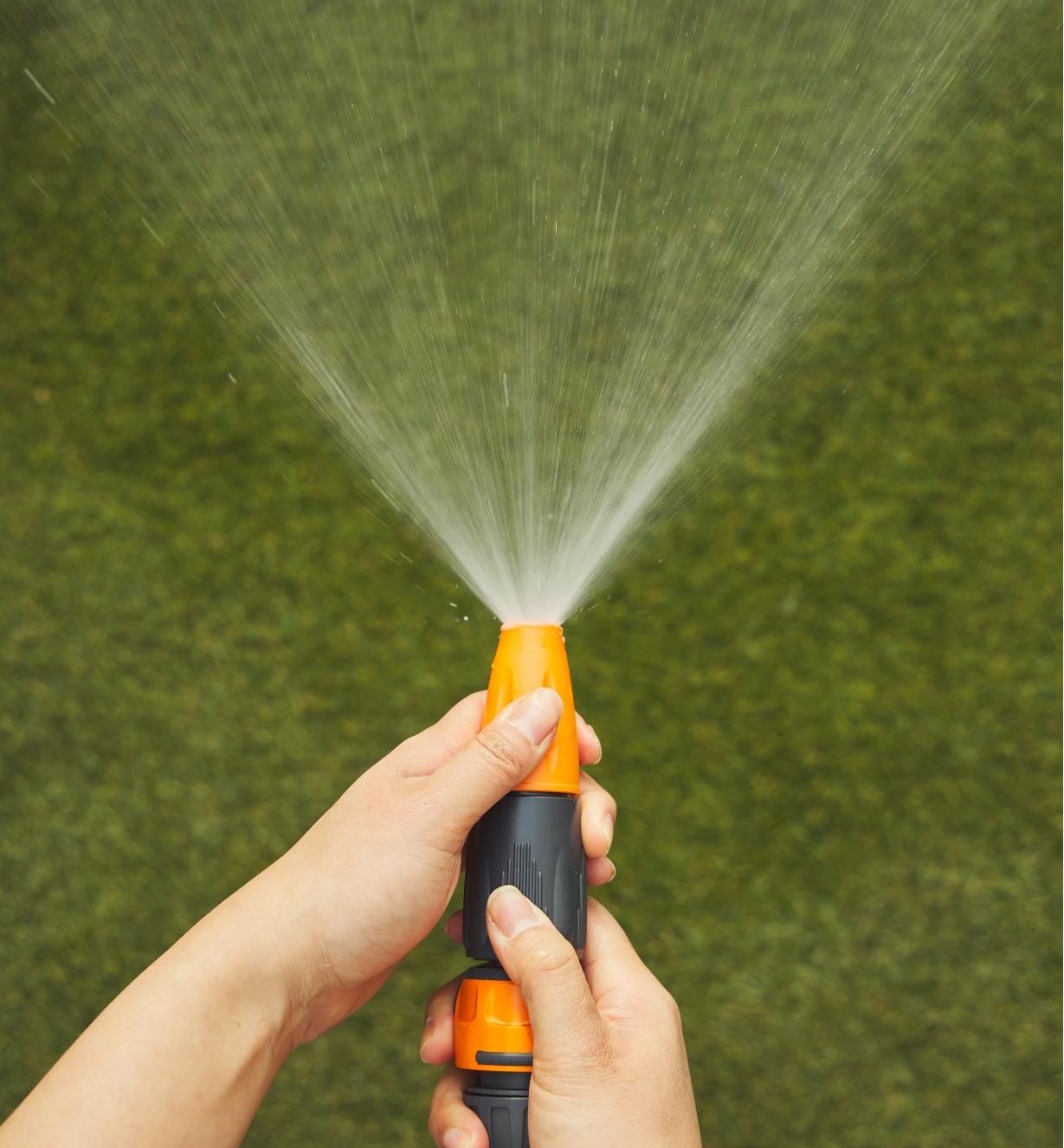 The spray gun on the hose sprays a fan of water