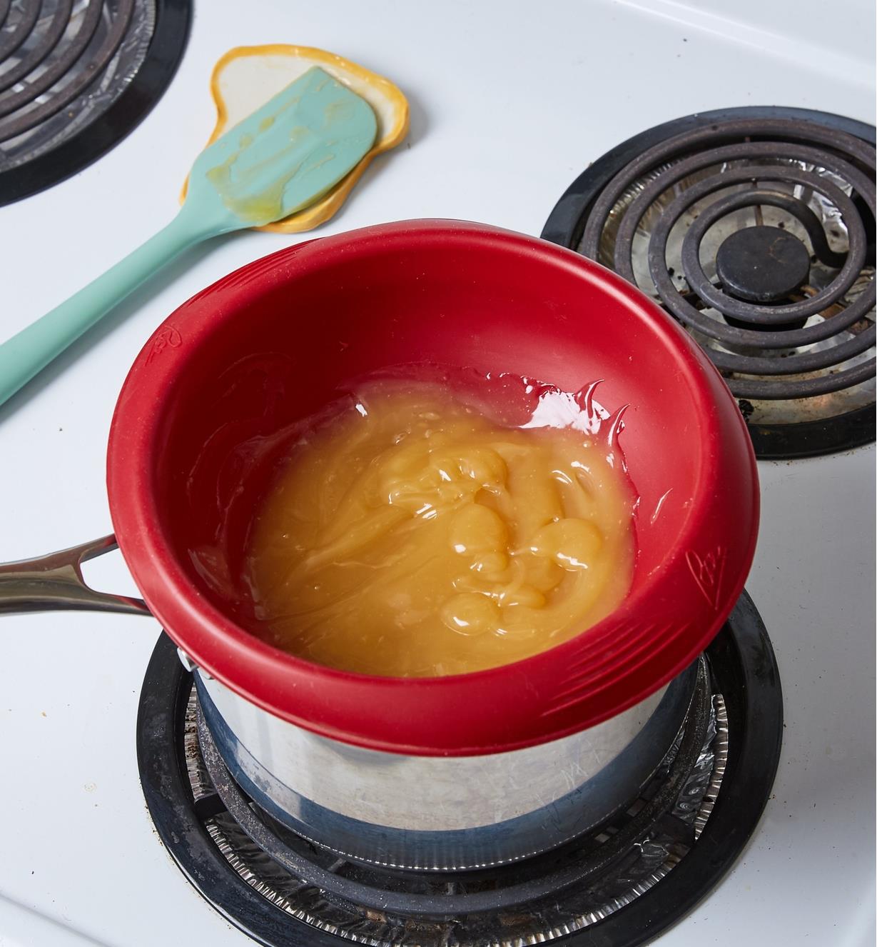 Bol en silicone contenant de la crème de citron, déposé dans une casserole sur une cuisinière