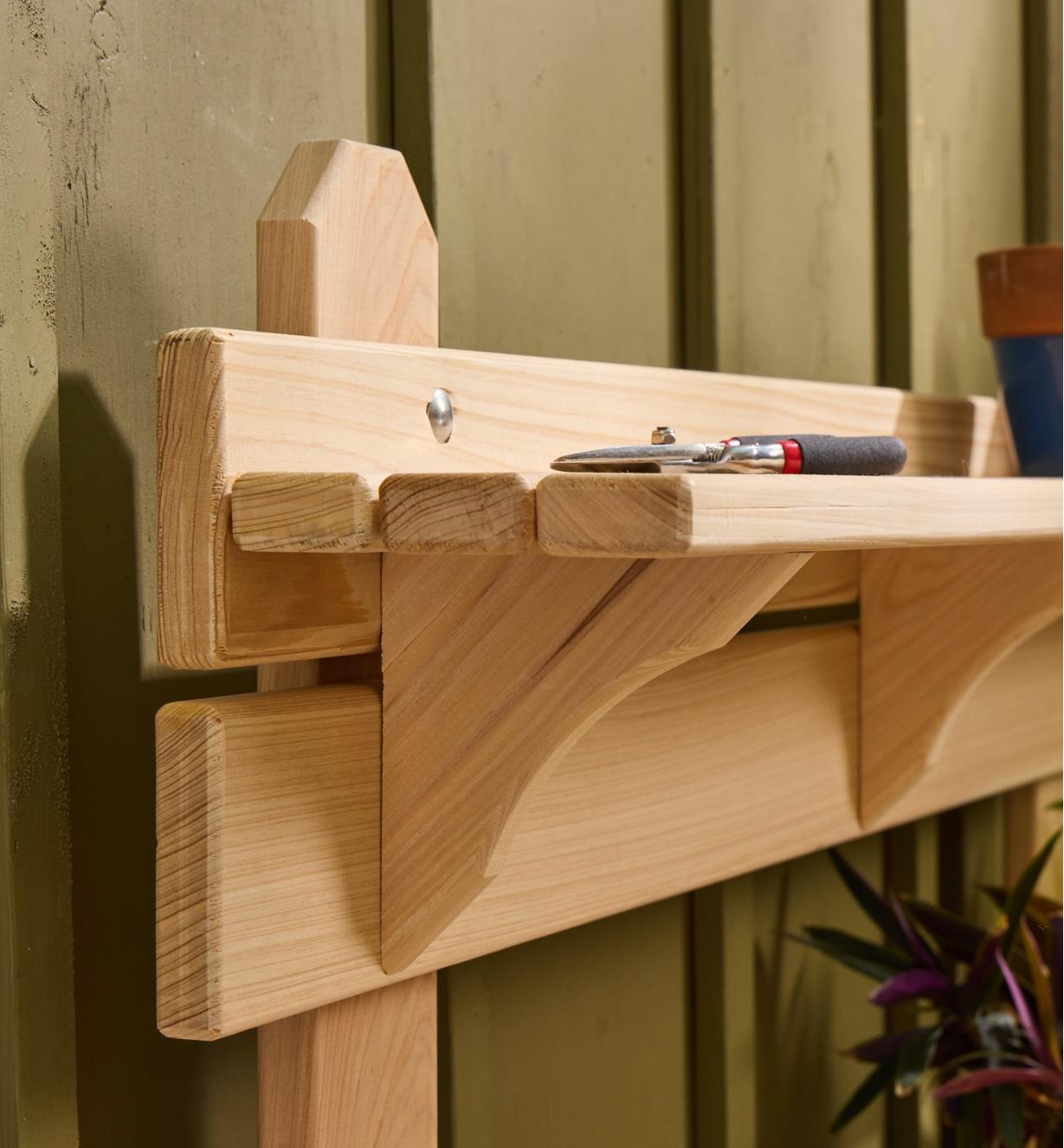 A close-up view of the shelf on the cypress potting table