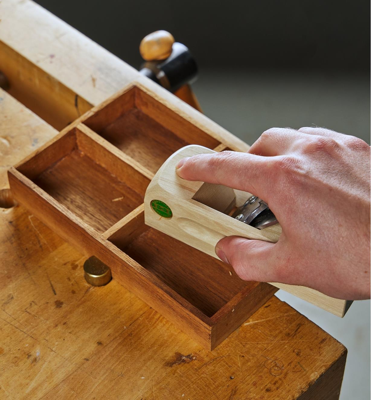 Using the block plane to level the dividers in a small tray