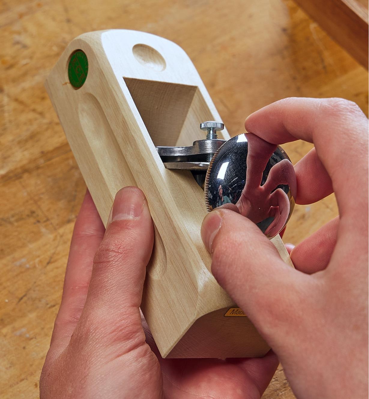 Adjusting the regulator knob on the block plane