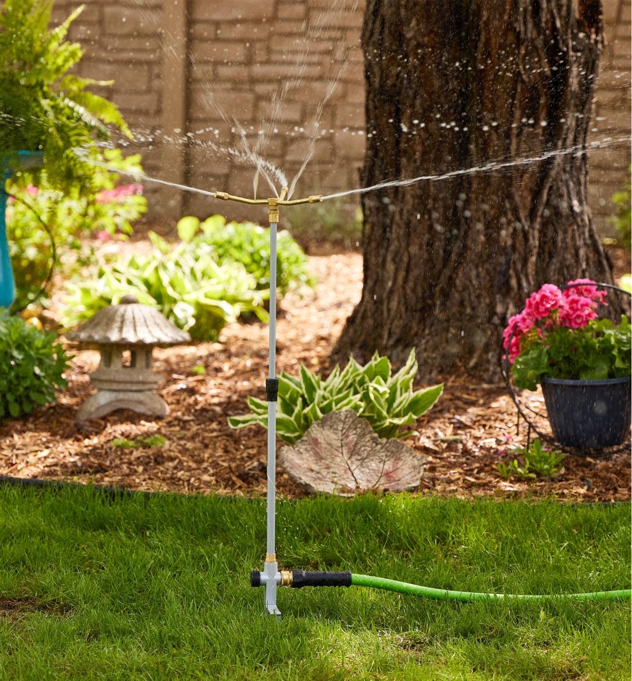 A telescoping sprinkler spraying a wide spray in a yard