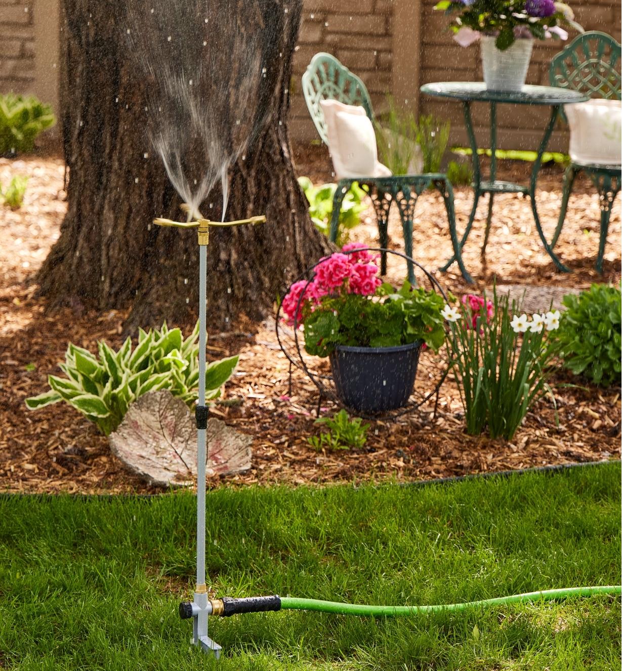 A telescoping sprinkler spraying water in a yard