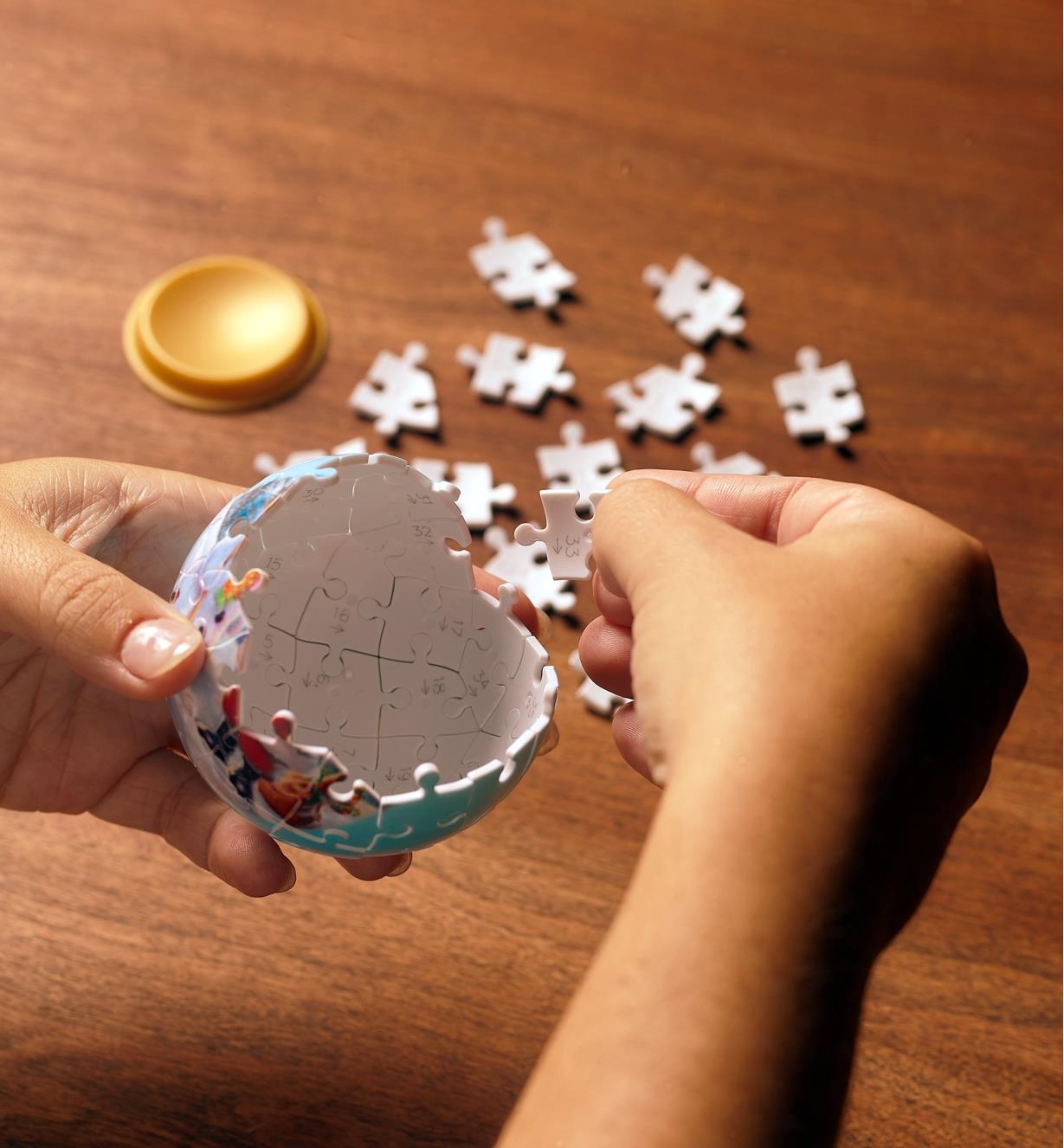 Personne assemblant une boule de Noël 3D