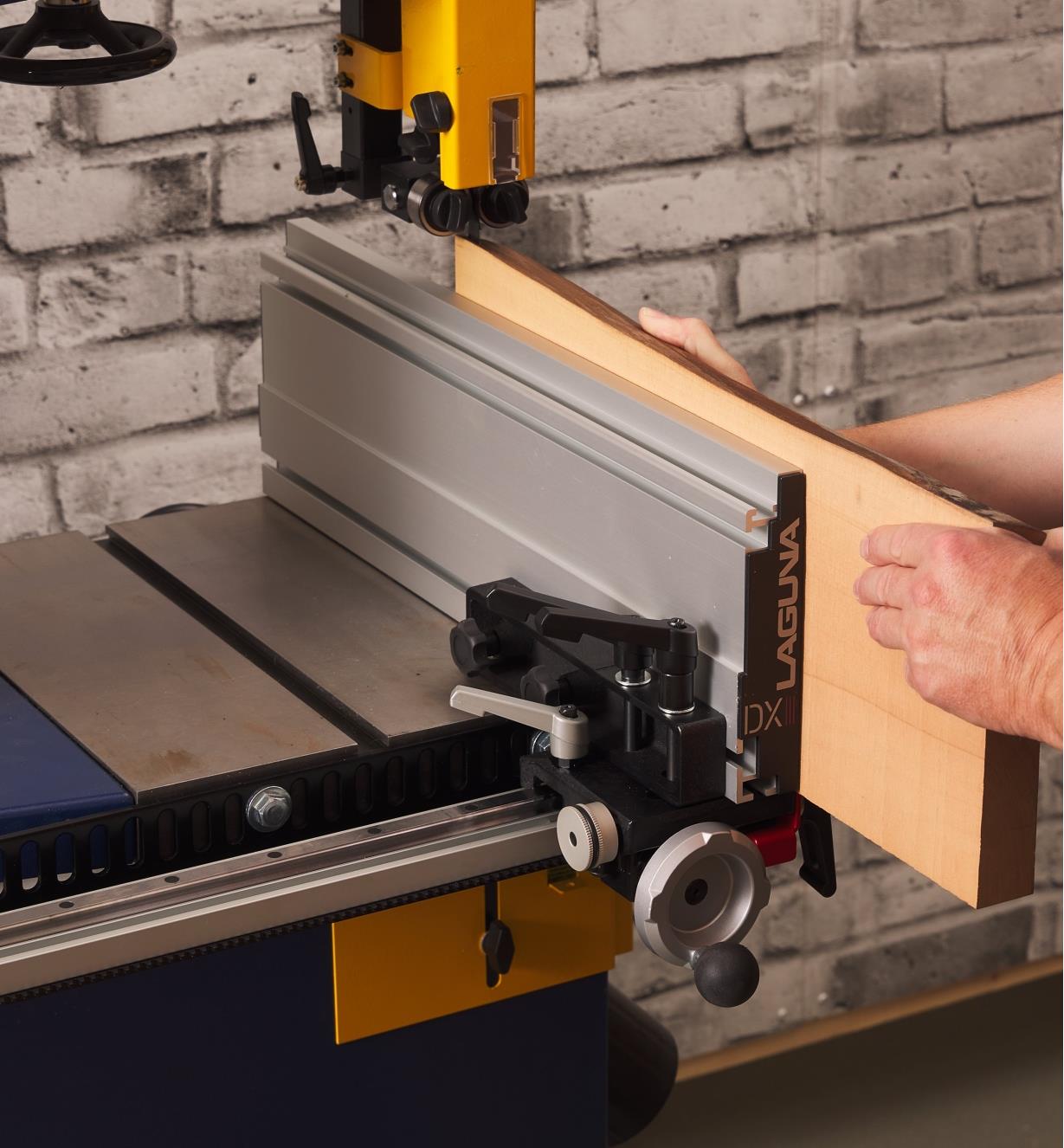 A Laguna DX3 Driftmaster bandsaw fence mounted on a bandsaw table in the vertical orientation