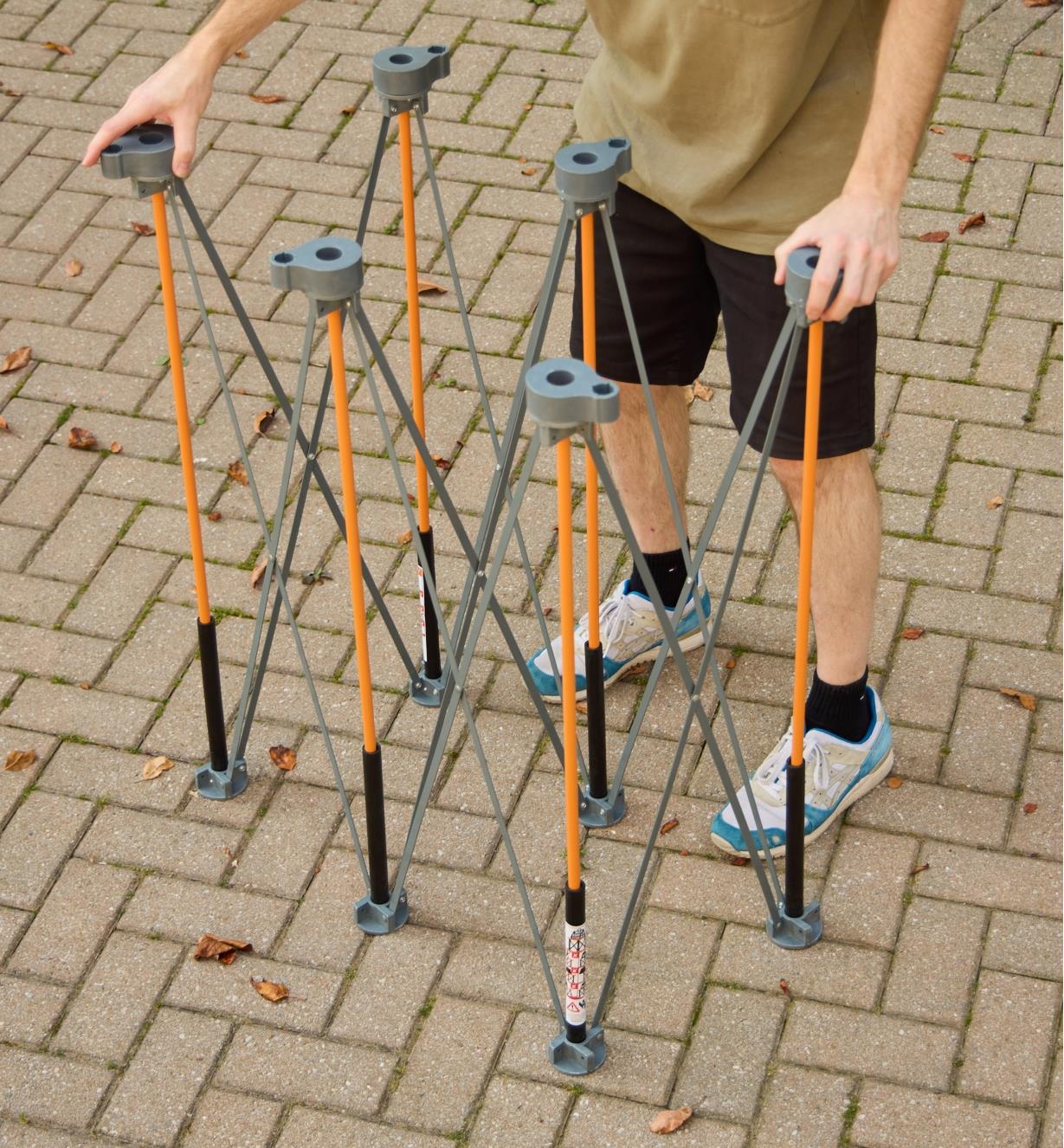 A man unfolds a Bora Centipede table in a driveway