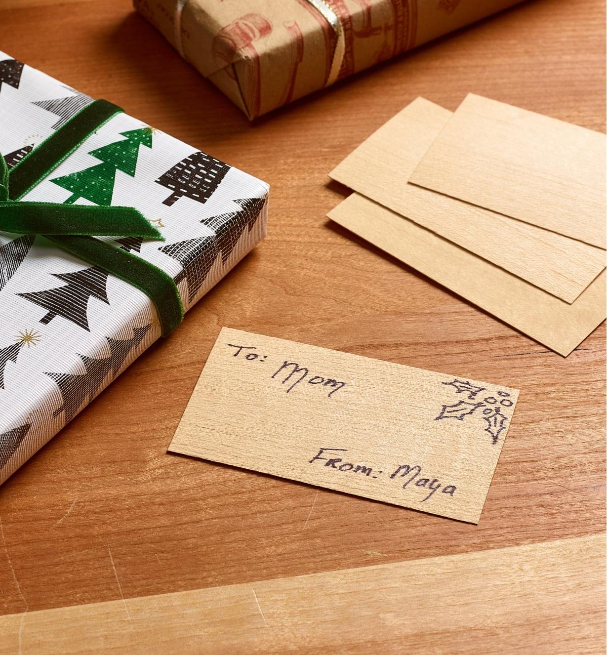 A Veneer Business Card with writing on it sits on a table next to wrapped gifts and more blank veneer cards