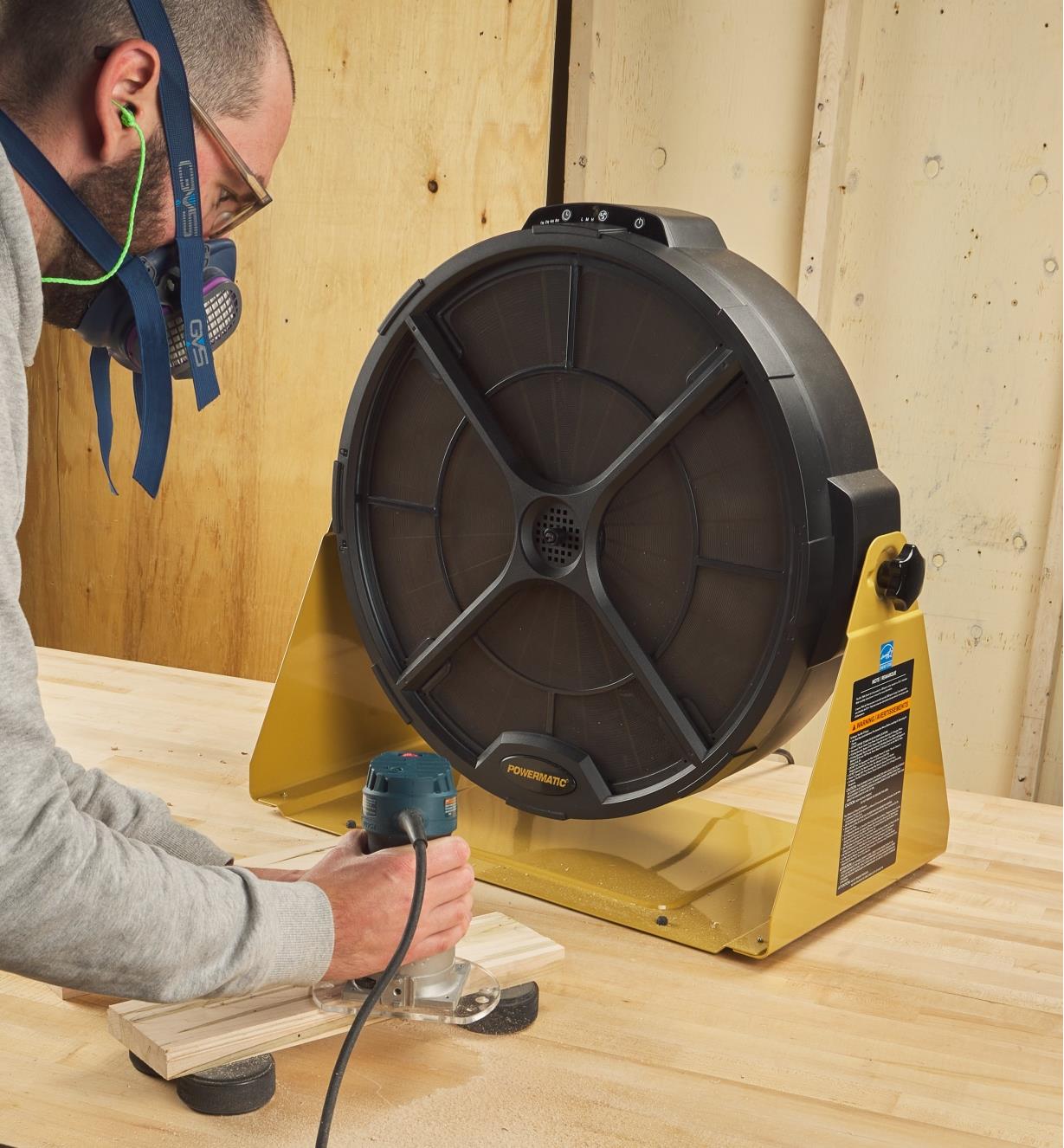 A palm router being used in front of an air filtration system