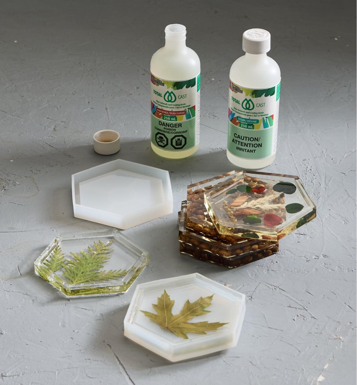 Bottles of epoxy resin and hardener next to three cured epoxy coasters and a coaster still in a mold